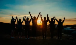 Grupo de amigos disfrutando de la puesta de sol | Qué Onda