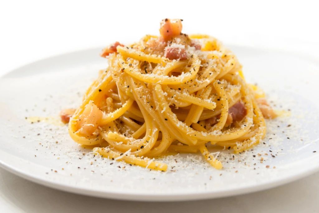 Bucatini alla Carbonara, receta italiana típica de pasta con guanciale, huevo y queso pecorino romano | Qué Onda