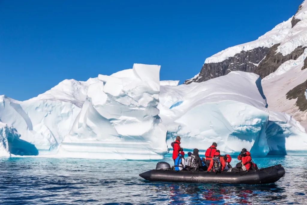Turistas exploran enormes icebergs a la deriva en la bahía cerca de la isla Cuverville, península Antártica | Qué Onda