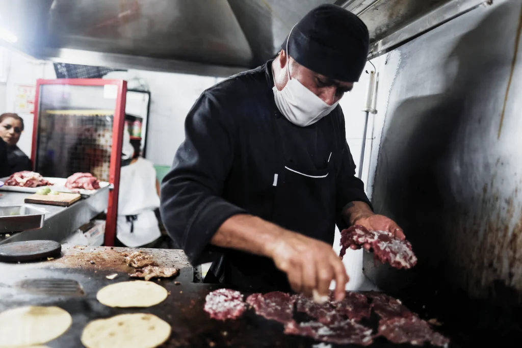 Empleado cocinando las carnitas para preparar los tacos | Taquería El Califa de León | Qué Onda