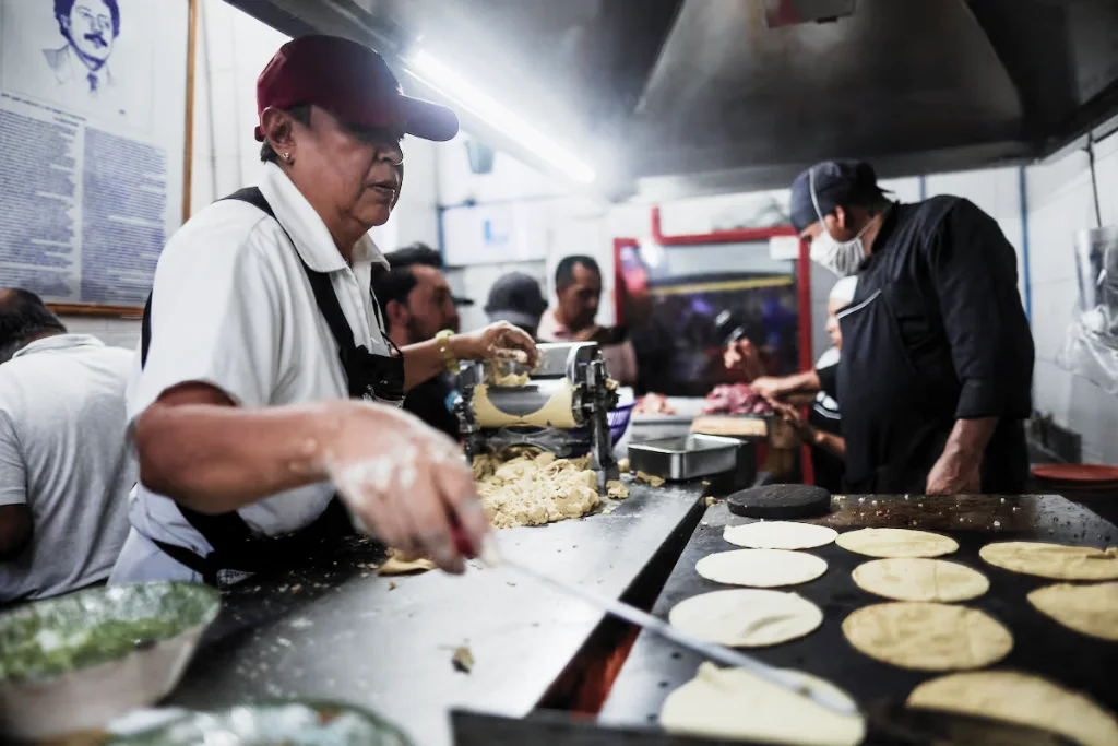 Una empleada hace tortillas para tacos en la Taquería El Califa de León CDMX, México | Qué Onda