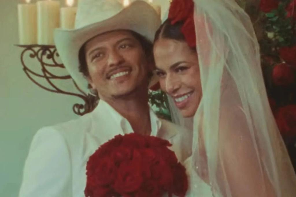 Bruno Mars The Romantic Album Video muestra a Mars vestido de blanco con sombrero de vaquero junto a su novia en la escena de la boda | Qué Onda