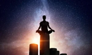 Júpiter en Cáncer representado por una silueta meditando sobre rocas bajo un cielo estelar | Qué Onda