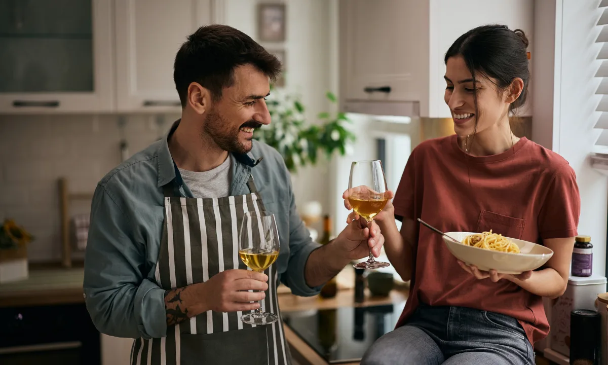 Vinos Bajos en Alcohol Una pareja sonriente brinda con copas de vino blanco | Qué Onda