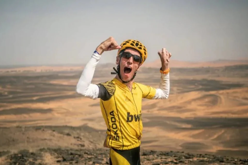 Alex Roca festeja con júbilo en el desierto tras completar una etapa de ciclismo | Qué Onda